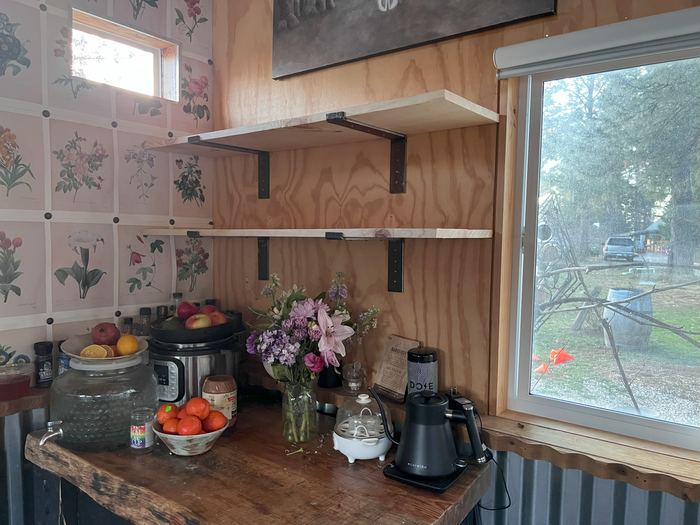 Steel shelf brackets holding open wood shelves in a kitchen