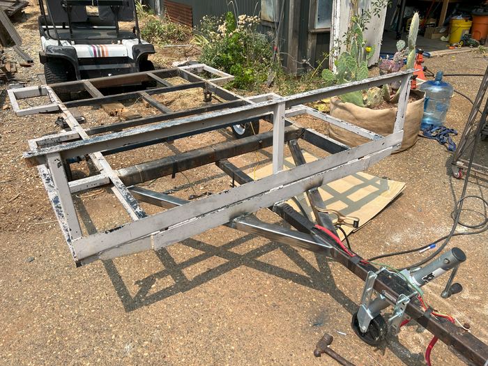 Utility trailer stripped to its frame for a custom modification