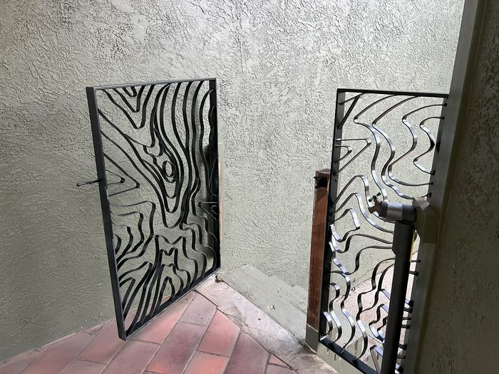 Topograin breezeway gate swung open onto a brick walkway