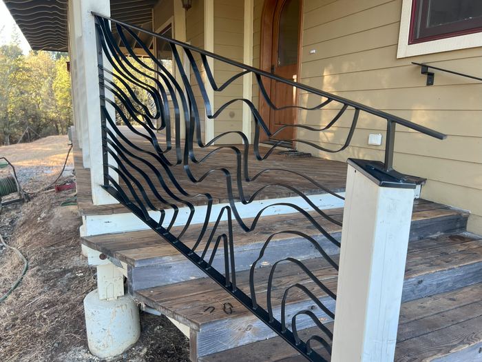 Topograin stair railing following the porch steps down to the yard